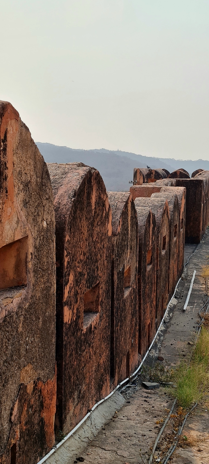 A pair of stairs and a part of massive solid fencing wall in a perfect geometrical design